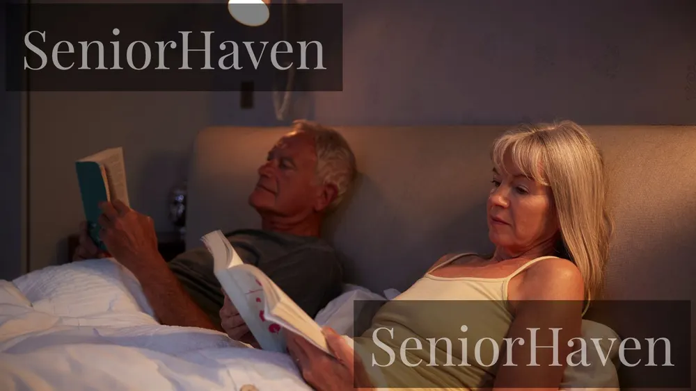 An older couple sitting up in bed reading in a warm bedroom