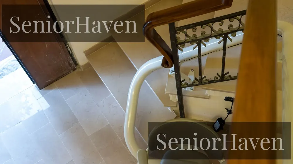A curved stairlift rail bending around a landing turn on an indoor staircase
