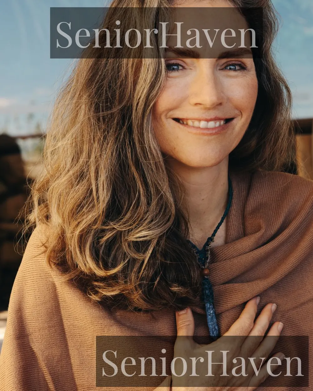 A smiling woman wearing a pendant necklace