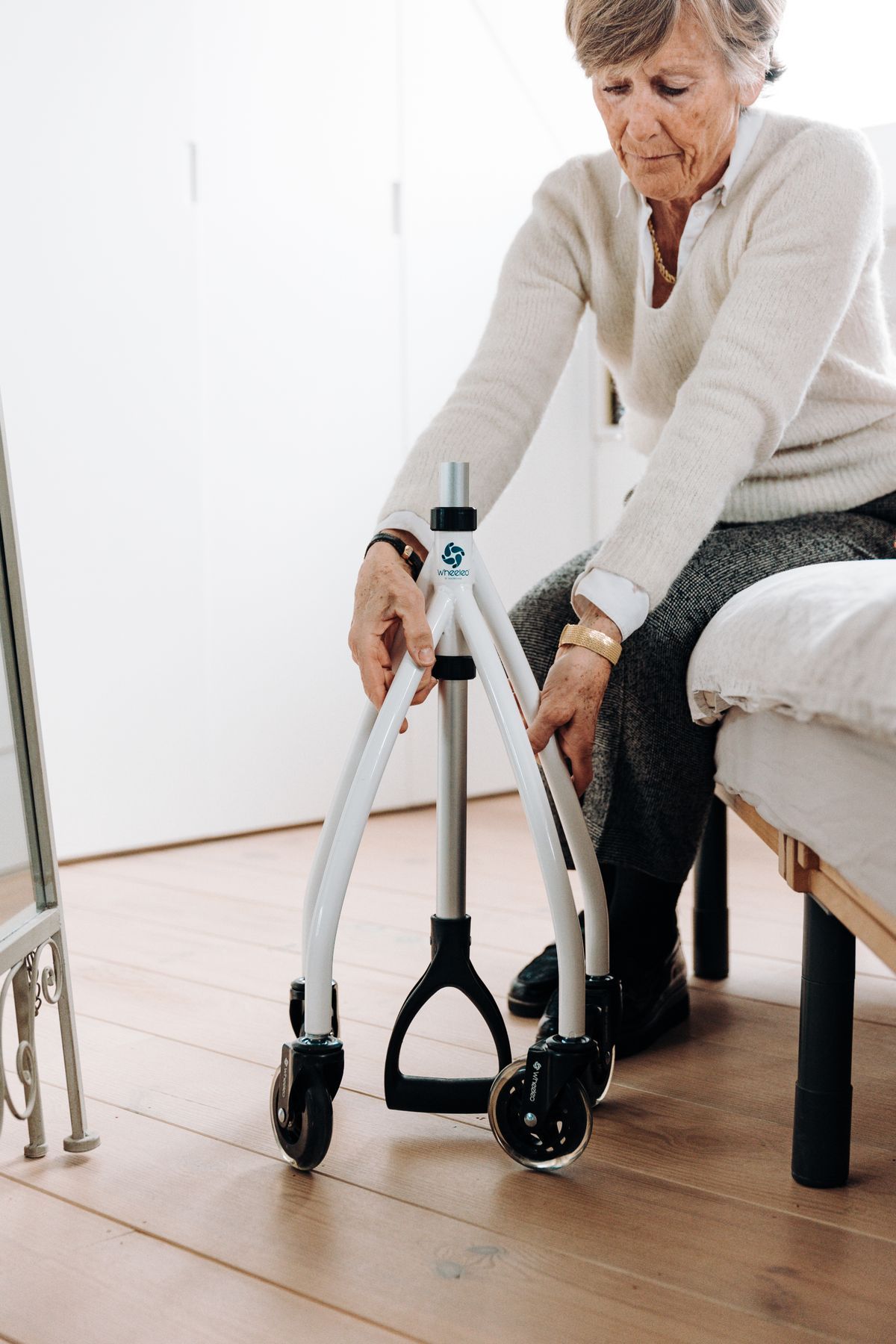 An older woman using a rollator walker inside her home